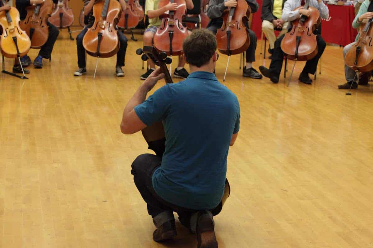 Ben kneels w cello lower bouts